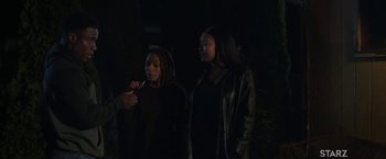Movie still from “A Journal for Jordan” (2021), directed by Denzel Washington – Two young women standing next to each other in the dark; Medium shot, Over the shoulder angle