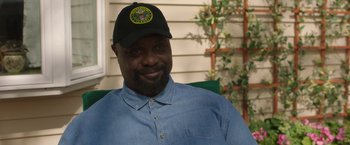 Movie still from “A Journal for Jordan” (2021), directed by Denzel Washington – A man wearing a hat sitting on a chair; Close Up shot, Over the shoulder angle