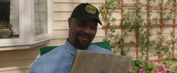 Movie still from “A Journal for Jordan” (2021), directed by Denzel Washington – A man sitting in a chair while reading a newspaper; Close Up shot, Over the shoulder angle