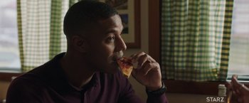 Movie still from “A Journal for Jordan” (2021), directed by Denzel Washington – A person eating a piece of pizza; Close Up shot, Over the shoulder angle