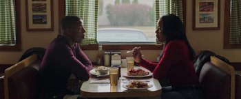 Movie still from “A Journal for Jordan” (2021), directed by Denzel Washington – A man and a woman sitting at a table with food; Medium shot, Over the shoulder angle