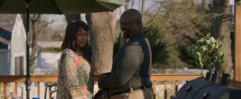 Movie still from “A Journal for Jordan” (2021), directed by Denzel Washington – A man and a woman standing next to each other under an umbrella; Medium shot, Over the shoulder angle