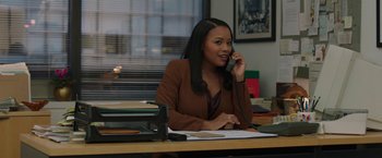 Movie still from “A Journal for Jordan” (2021), directed by Denzel Washington – A woman sitting at a desk talking on the phone; Medium shot, Over the shoulder angle