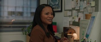 Movie still from “A Journal for Jordan” (2021), directed by Denzel Washington – A woman sitting at a table in front of a picture; Medium shot, Over the shoulder angle
