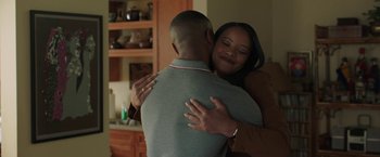 Movie still from “A Journal for Jordan” (2021), directed by Denzel Washington – A man and a woman hugging in a kitchen; Medium shot, Over the shoulder angle