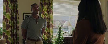 Movie still from “A Journal for Jordan” (2021), directed by Denzel Washington – A man standing in front of a window in a room; Medium shot, Over the shoulder angle