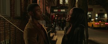 Movie still from “A Journal for Jordan” (2021), directed by Denzel Washington – A man and a woman standing next to each other on a sidewalk; Medium shot, Over the shoulder angle