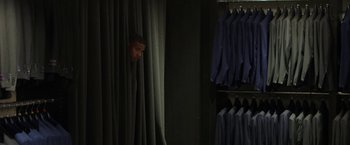 Movie still from “A Journal for Jordan” (2021), directed by Denzel Washington – A man peeks out from behind a curtain in a closet; Wide shot, High angle