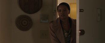 Movie still from “A Journal for Jordan” (2021), directed by Denzel Washington – A woman wearing a brown coat standing next to a wall; Medium shot, Over the shoulder angle
