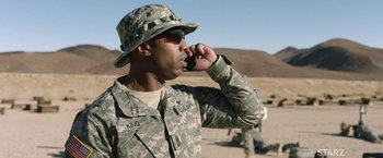 Movie still from “A Journal for Jordan” (2021), directed by Denzel Washington – A man in fatigues talking on a cell phone; Close Up shot, Low angle