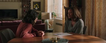 Movie still from “A Journal for Jordan” (2021), directed by Denzel Washington – Two women sitting at a table in front of papers; Medium shot, Over the shoulder angle