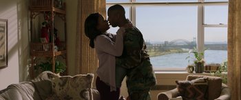 Movie still from “A Journal for Jordan” (2021), directed by Denzel Washington – A man and a woman kissing in front of a window; Medium shot, Over the shoulder angle