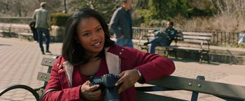 Movie still from “A Journal for Jordan” (2021), directed by Denzel Washington – A woman holding a camera and smiling for the camera; Close Up shot, Over the shoulder angle