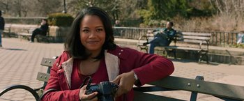 Movie still from “A Journal for Jordan” (2021), directed by Denzel Washington – A woman holding a camera while standing on a bench; Close Up shot, Over the shoulder angle