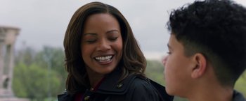 Movie still from “A Journal for Jordan” (2021), directed by Denzel Washington – A woman smiles as she talks to another person; Close Up shot, Over the shoulder angle