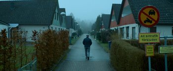 Movie still from “A Man Called Ove” (2015), directed by Hannes Holm – A man walking down a street in a residential area; Wide shot, Low angle