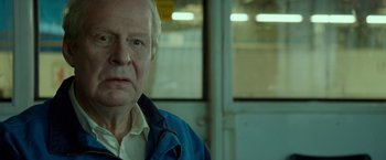 Movie still from “A Man Called Ove” (2015), directed by Hannes Holm – An older man in a blue jacket looking at the camera; Close Up shot, Over the shoulder angle