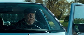 Movie still from “A Man Called Ove” (2015), directed by Hannes Holm – An older man driving a car in a forest; Close Up shot, Low angle