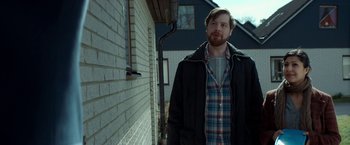 Movie still from “A Man Called Ove” (2015), directed by Hannes Holm – A man standing in front of a brick building; Medium shot, Over the shoulder angle