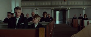 Movie still from “A Man Called Ove” (2015), directed by Hannes Holm – A group of people sitting in pews in a church; Medium shot, Over the shoulder angle