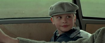 Movie still from “A Man Called Ove” (2015), directed by Hannes Holm – A young boy wearing a hat sitting in a car; Close Up shot, Over the shoulder angle