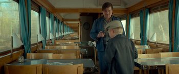 Movie still from “A Man Called Ove” (2015), directed by Hannes Holm – A man standing next to a young boy in a train car; Medium shot, Over the shoulder angle