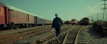 Movie still from “A Man Called Ove” (2015), directed by Hannes Holm – A man is walking down the train tracks; Wide shot, Low angle