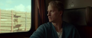 A man sitting in front of a window looking out