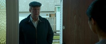 Movie still from “A Man Called Ove” (2015), directed by Hannes Holm – An older man standing in front of an open door; Medium shot, Over the shoulder angle