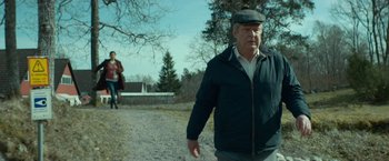 Movie still from “A Man Called Ove” (2015), directed by Hannes Holm – An older man walking on a dirt road; Medium shot, Over the shoulder angle