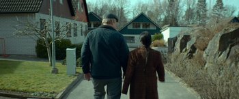 Movie still from “A Man Called Ove” (2015), directed by Hannes Holm – An older man and a younger woman walking down a street; Medium shot, Low angle