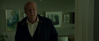 Movie still from “A Man Called Ove” (2015), directed by Hannes Holm – An older man standing in front of a painting; Medium shot, Low angle