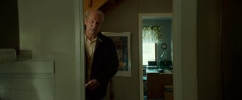 Movie still from “A Man Called Ove” (2015), directed by Hannes Holm – An older man leaning against a wall in a room; Medium shot, Low angle