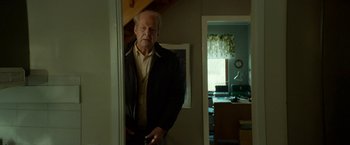 Movie still from “A Man Called Ove” (2015), directed by Hannes Holm – An older man standing in front of a mirror in a room; Medium shot, Low angle