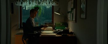 Movie still from “A Man Called Ove” (2015), directed by Hannes Holm – A man sitting at a desk in front of a window; Medium shot, Low angle