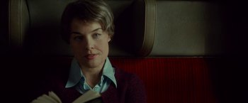 Movie still from “A Man Called Ove” (2015), directed by Hannes Holm – A woman sitting on a train holding a book; Close Up shot, Over the shoulder angle