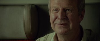 Movie still from “A Man Called Ove” (2015), directed by Hannes Holm – An older man is smiling for the camera; Close Up shot, Over the shoulder angle