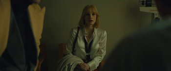 Movie still from “A Most Violent Year” (2014), directed by J.C. Chandor – A woman sitting in a chair wearing a white shirt; Medium shot, Over the shoulder angle