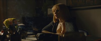 Movie still from “A Most Violent Year” (2014), directed by J.C. Chandor – A woman sitting in a chair with a book in front of her face; Medium shot, Low angle