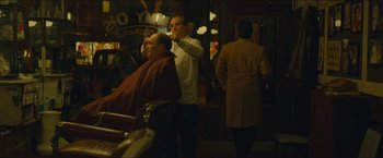 Movie still from “A Most Violent Year” (2014), directed by J.C. Chandor – A man getting his hair cut at a barber shop; Medium shot, Over the shoulder angle