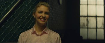 Movie still from “A Most Violent Year” (2014), directed by J.C. Chandor – A woman in a pink shirt smiling for the camera; Close Up shot, Over the shoulder angle