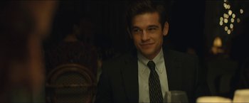 Movie still from “A Most Violent Year” (2014), directed by J.C. Chandor – A man wearing a suit and tie smiling for the camera; Close Up shot, Over the shoulder angle
