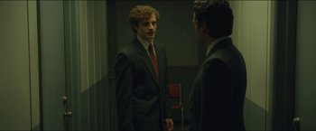 Movie still from “A Most Violent Year” (2014), directed by J.C. Chandor – A man in a suit and tie standing next to another man in a suit and tie; Medium shot, Over the shoulder angle