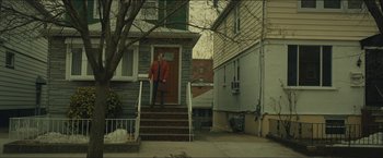 Movie still from “A Most Violent Year” (2014), directed by J.C. Chandor – A man standing on the front steps of a house; Extreme Wide shot, Low angle