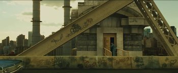 Movie still from “A Most Violent Year” (2014), directed by J.C. Chandor – A man standing in front of a building next to stairs; Extreme Wide shot, High angle