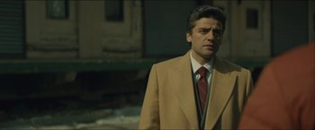 Movie still from “A Most Violent Year” (2014), directed by J.C. Chandor – A man in a suit and tie standing in front of a building; Medium shot, Low angle