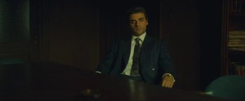 Movie still from “A Most Violent Year” (2014), directed by J.C. Chandor – A man sitting at a table wearing a suit and tie; Medium shot, Low angle