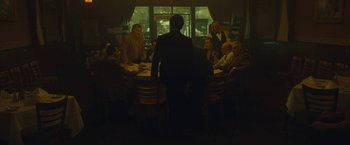 Movie still from “A Most Violent Year” (2014), directed by J.C. Chandor – A group of people sitting around a table at night; Wide shot, High angle