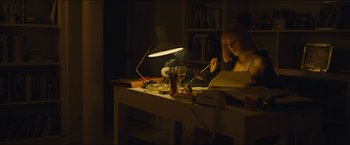 Movie still from “A Most Violent Year” (2014), directed by J.C. Chandor – A woman sitting at a desk writing on a piece of paper; Medium shot, High angle