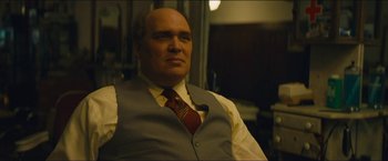 Movie still from “A Most Violent Year” (2014), directed by J.C. Chandor – A man in a vest and tie sitting in a chair; Medium shot, Over the shoulder angle